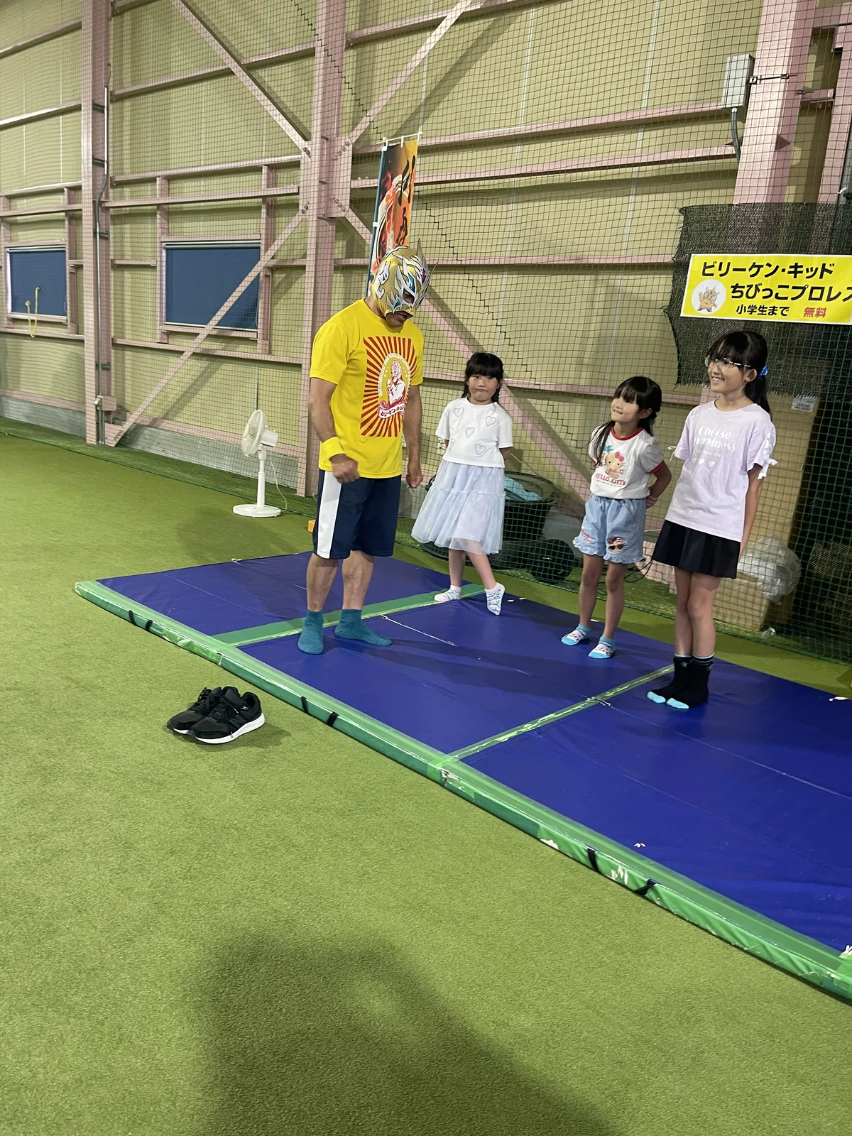 ビリーケン・キッドさんと子どもたちがマットの上でポーズをとる様子